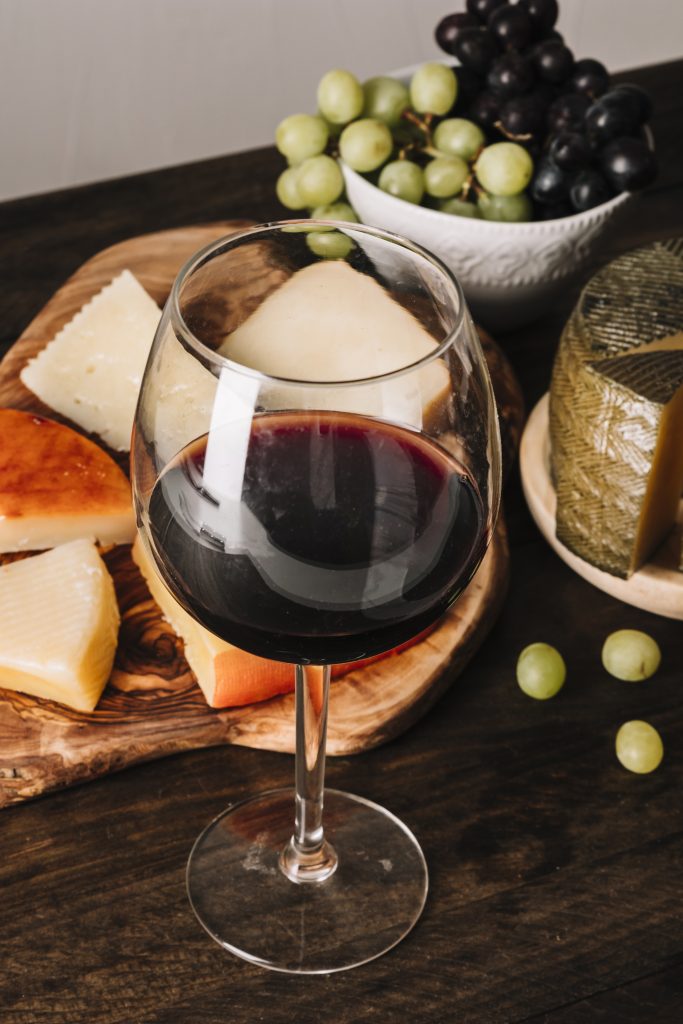glass wine near grapes cheese